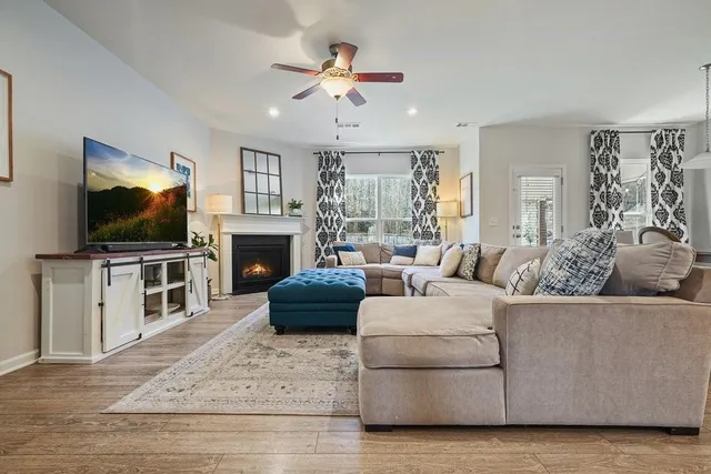 a living room with furniture a dining table and a chandelier