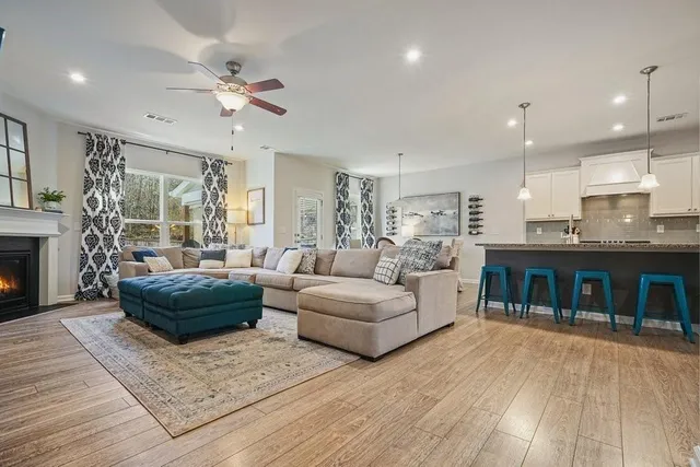 a kitchen with stainless steel appliances granite countertop a refrigerator a sink dishwasher a stove and white countertops with wooden floor