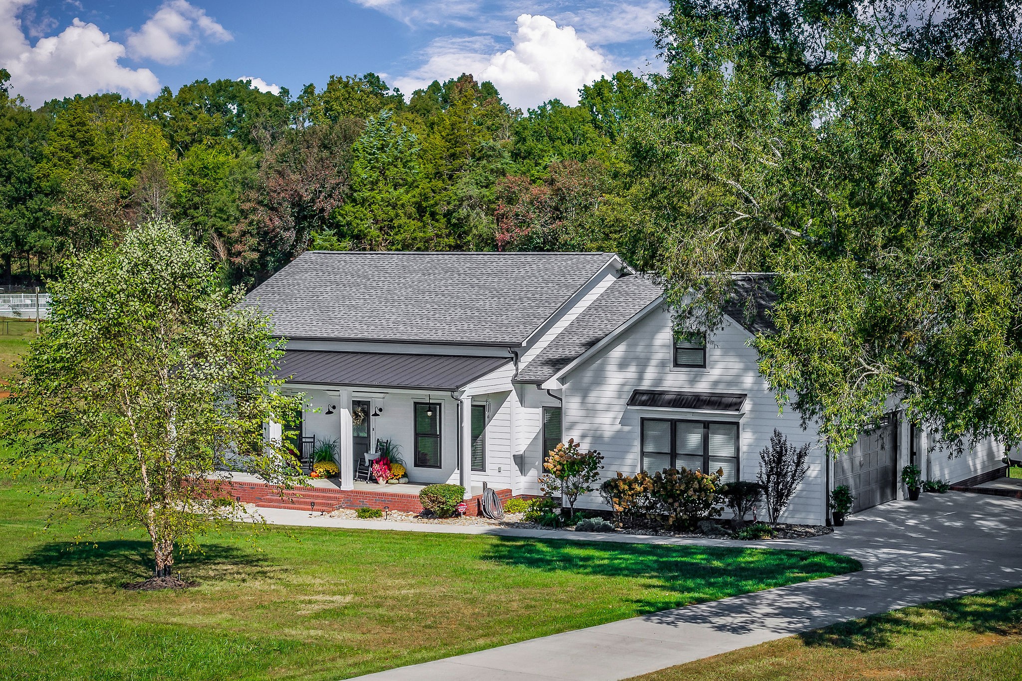 a front view of a house with a garden and trees