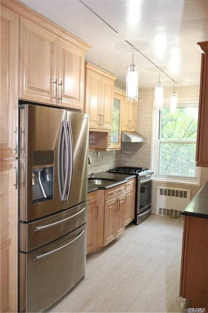 a kitchen with stainless steel appliances granite countertop a refrigerator and a sink