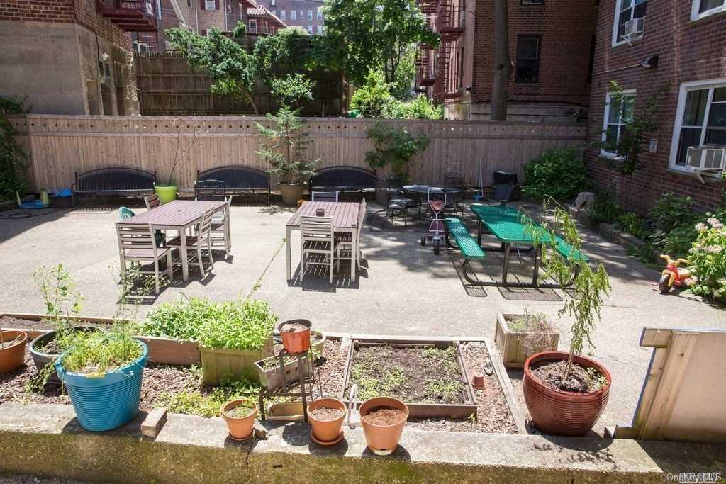 34-10 75th Street, Unit K2 Queens, NY 11372 - Photo 15 of 16 a view of a backyard with chair and potted plants