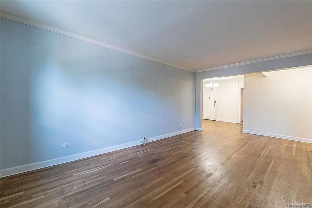 34-10 75th Street, Unit K2 Queens, NY 11372 - Photo 5 of 16 a view of an empty room with wooden floor and a window