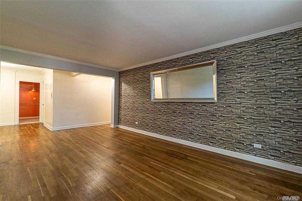 34-10 75th Street, Unit K2 Queens, NY 11372 - Photo 6 of 16 a view of an empty room with wooden floor and a window