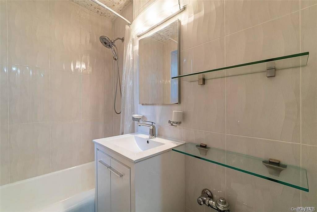 34-10 75th Street, Unit K2 Queens, NY 11372 - Photo 7 of 16 a bathroom with a sink and mirror