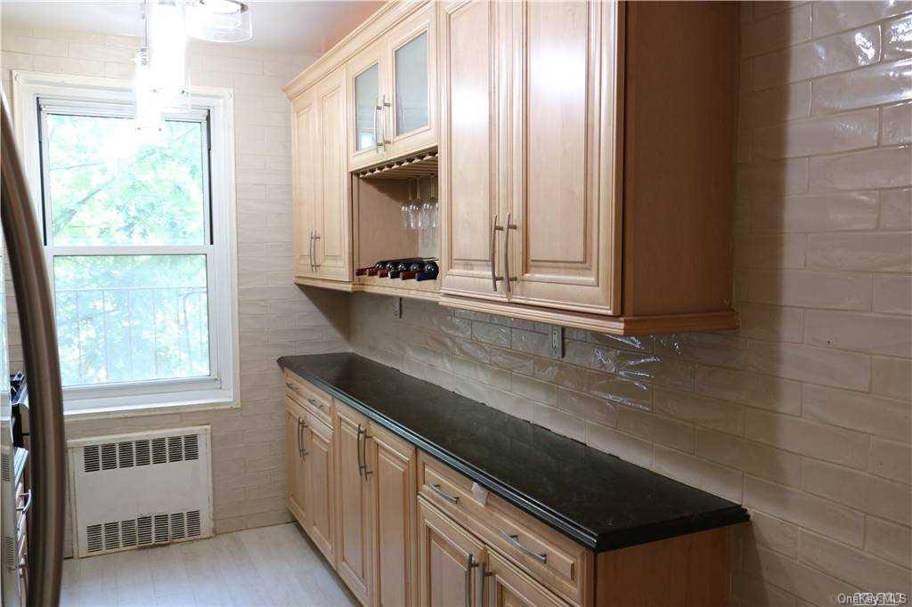 34-10 75th Street, Unit K2 Queens, NY 11372 - Photo 9 of 16 a kitchen with granite countertop a sink and a stove
