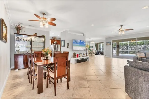 a view of a dining room and livingroom with furniture a floor to ceiling window and a chandelier