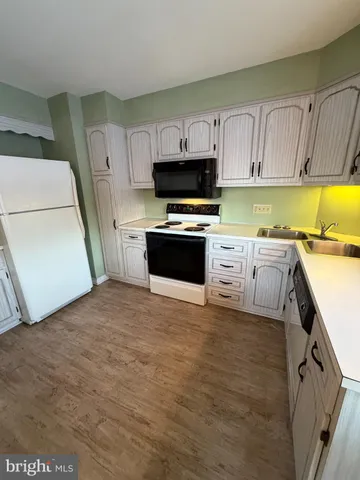 a kitchen with stainless steel appliances a stove a sink and white cabinets