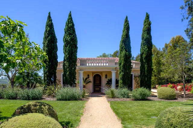a front view of a house with a garden and plants