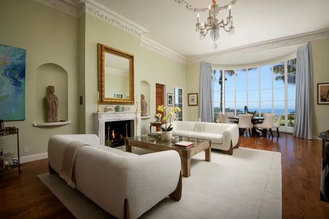 a living room with furniture a fireplace and a chandelier