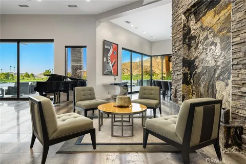 a view of dining room kitchen with stainless steel appliances kitchen island granite countertop a table chairs and a sink