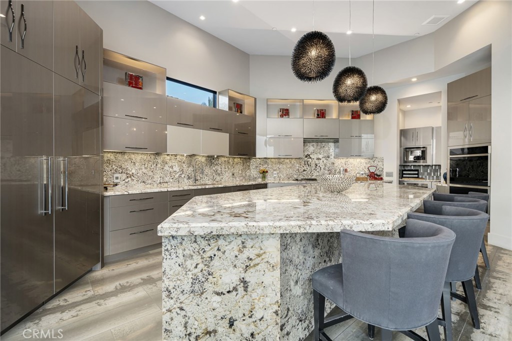49967 Ridge View Way Palm Desert, CA 92260 - Photo 22 of 68 a kitchen with kitchen island stainless steel appliances a sink cabinets and living room view