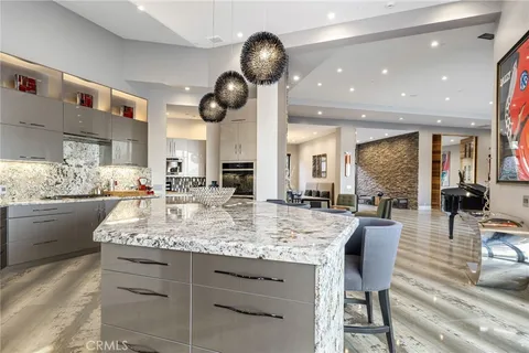 a kitchen with stainless steel appliances kitchen island granite countertop a table and chairs in it