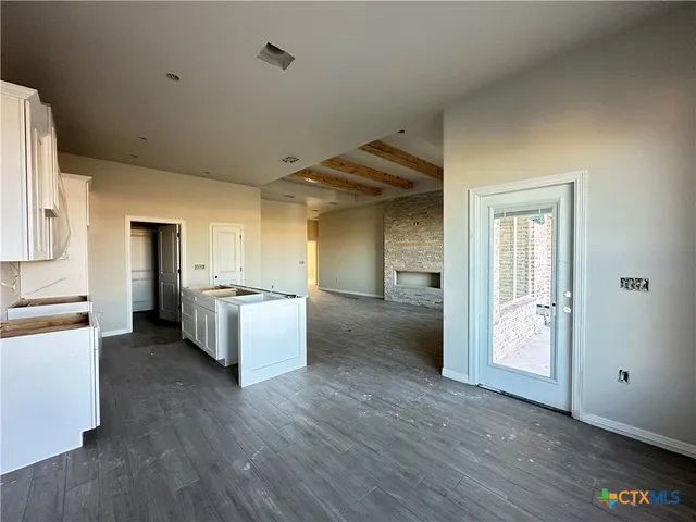a view of a kitchen with wooden floor and electronic appliances