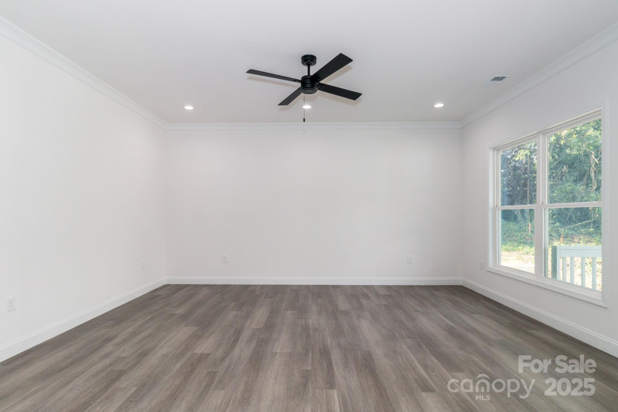 307 East Arch Street Lancaster, SC 29720 - Photo 12 of 43 an empty room with wooden floor and windows