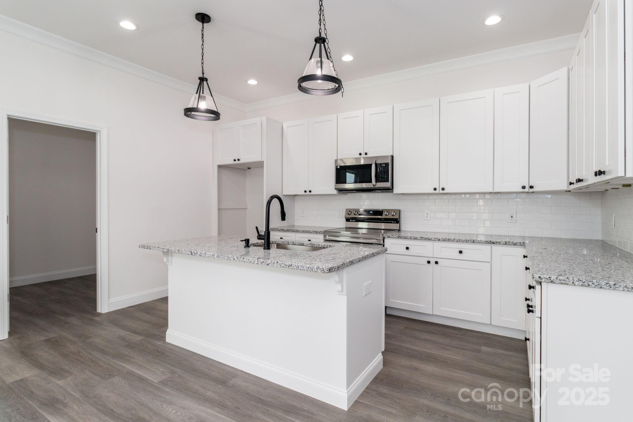 307 East Arch Street Lancaster, SC 29720 - Photo 18 of 43 a kitchen with stainless steel appliances granite countertop a sink a stove a refrigerator and cabinets