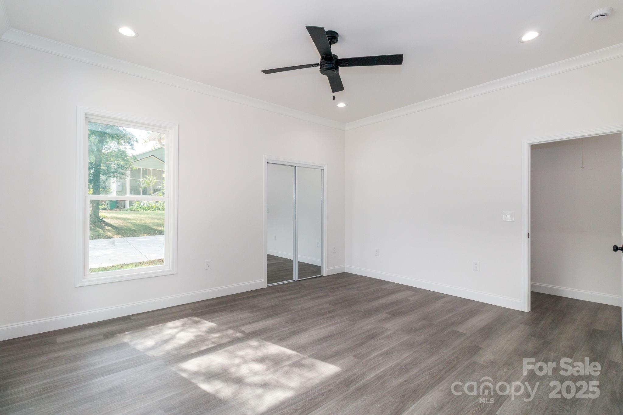 307 East Arch Street Lancaster, SC 29720 - Photo 26 of 43 an empty room with wooden floor and windows