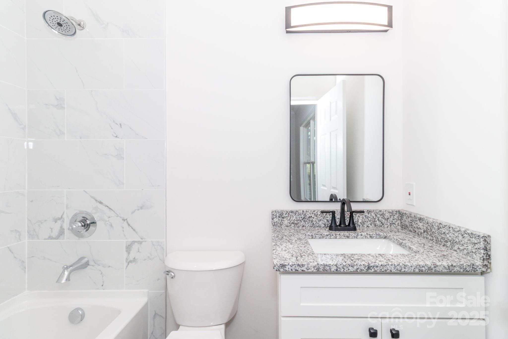 307 East Arch Street Lancaster, SC 29720 - Photo 28 of 43 a bathroom with a granite countertop sink a toilet and bathtub