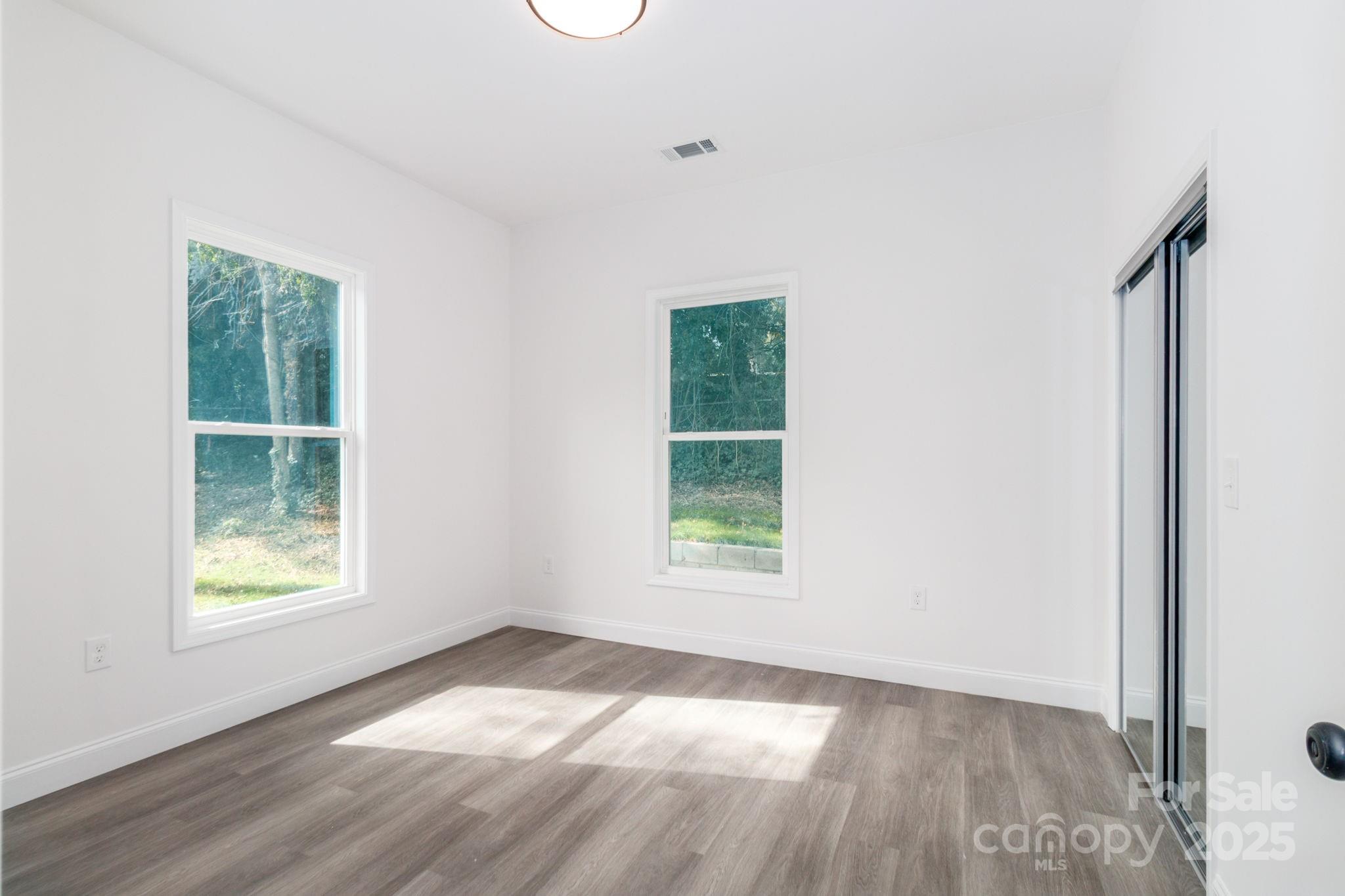 307 East Arch Street Lancaster, SC 29720 - Photo 30 of 43 an empty room with wooden floor and windows