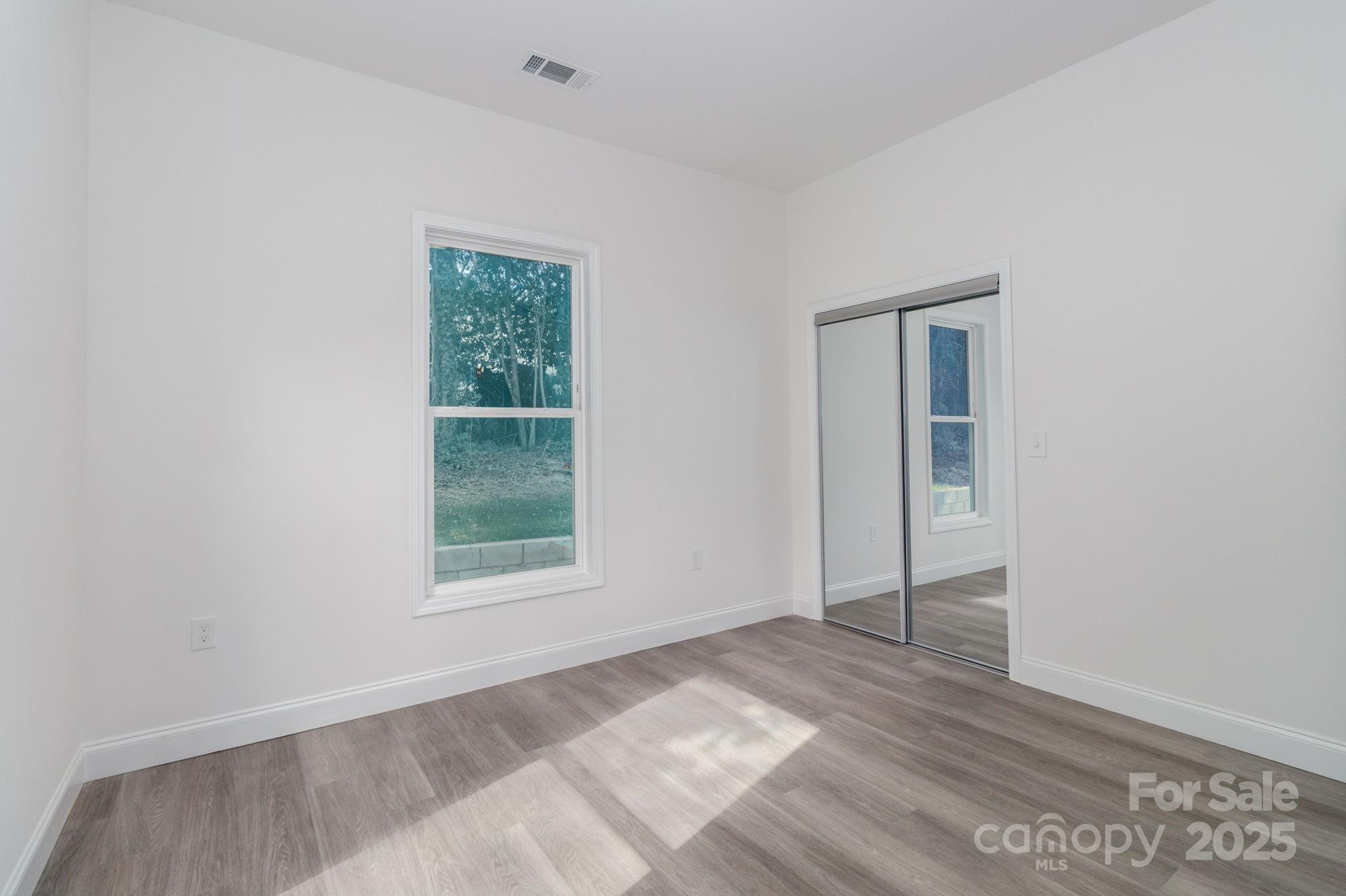 307 East Arch Street Lancaster, SC 29720 - Photo 31 of 43 an empty room with wooden floor and windows