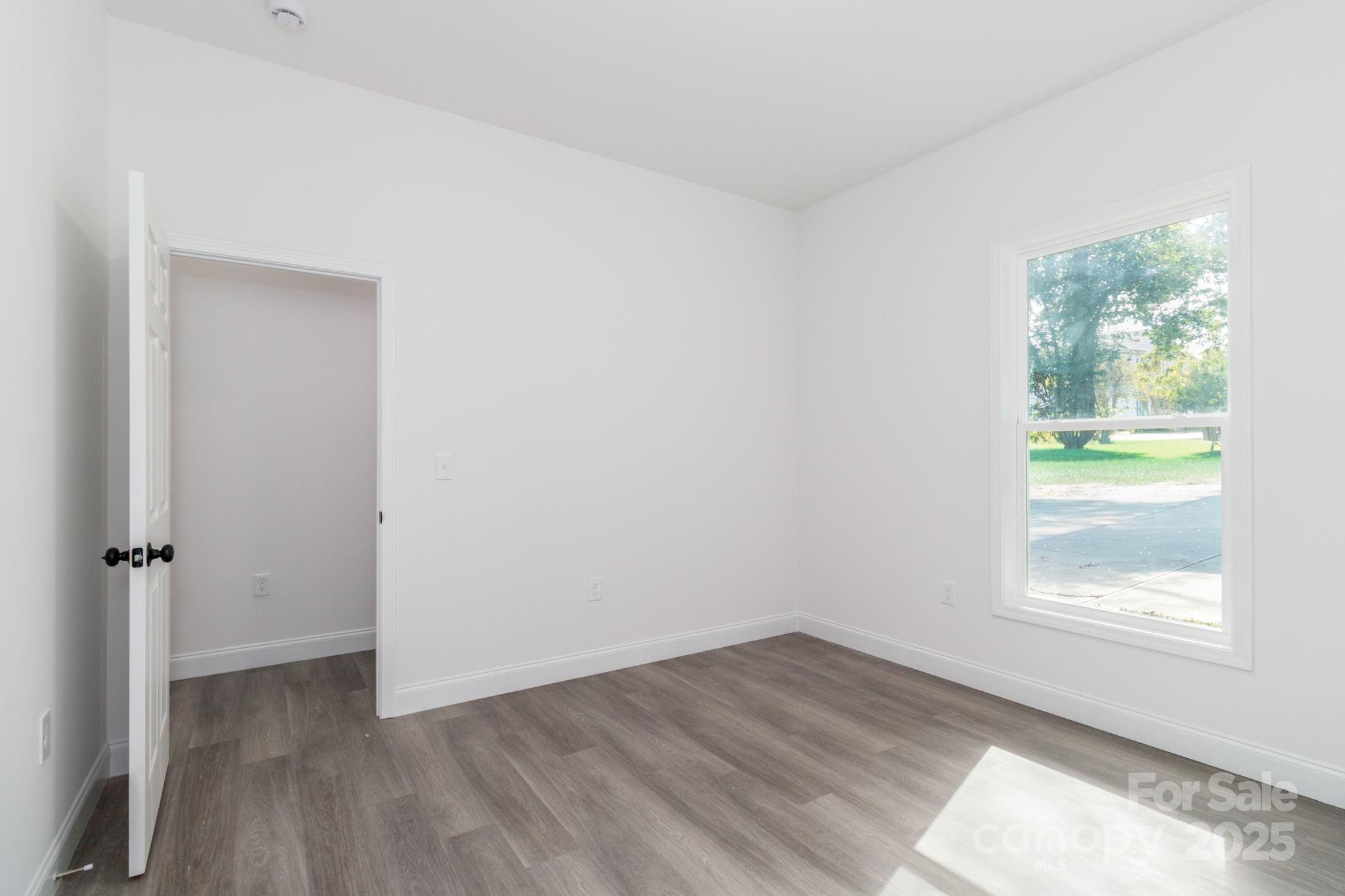 307 East Arch Street Lancaster, SC 29720 - Photo 32 of 43 an empty room with wooden floor and windows