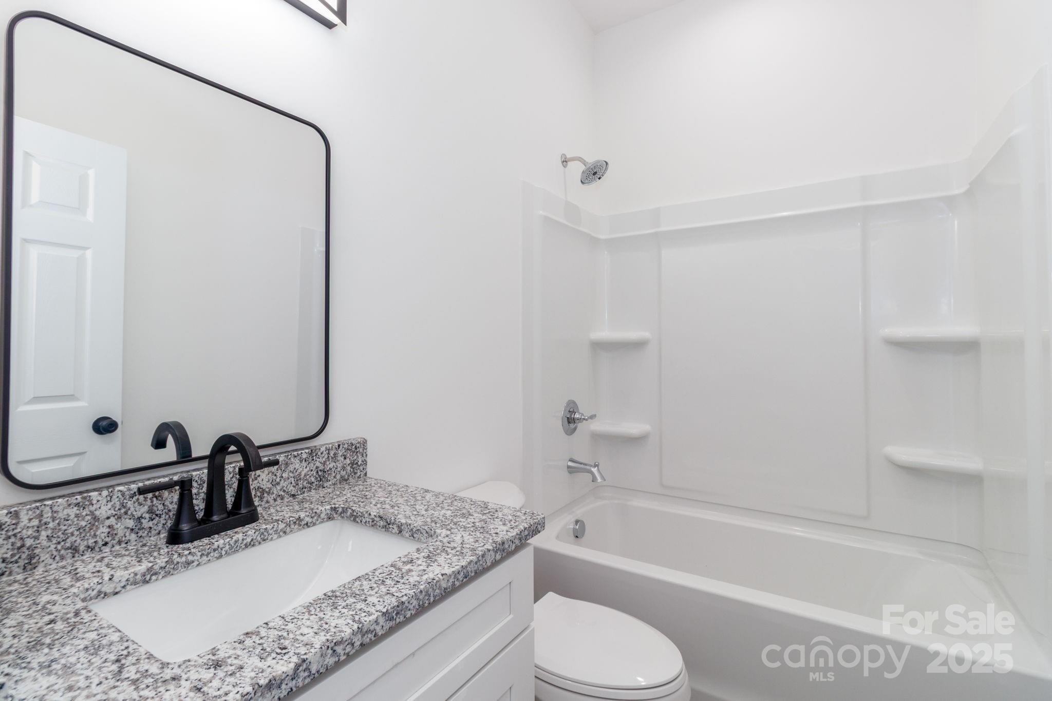 307 East Arch Street Lancaster, SC 29720 - Photo 33 of 43 a bathroom with a granite countertop sink toilet and shower