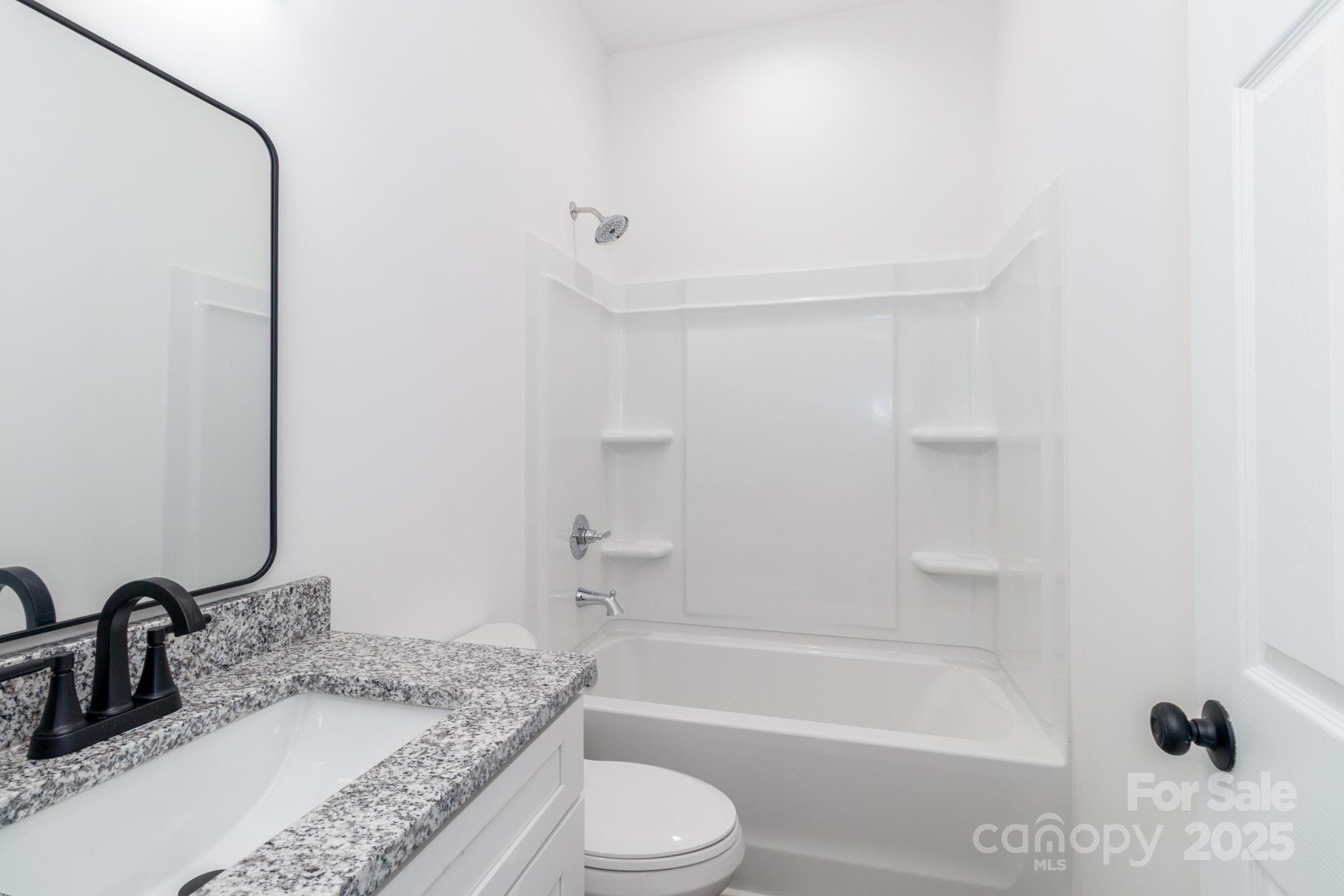 307 East Arch Street Lancaster, SC 29720 - Photo 34 of 43 a bathroom with a granite countertop sink a toilet and shower