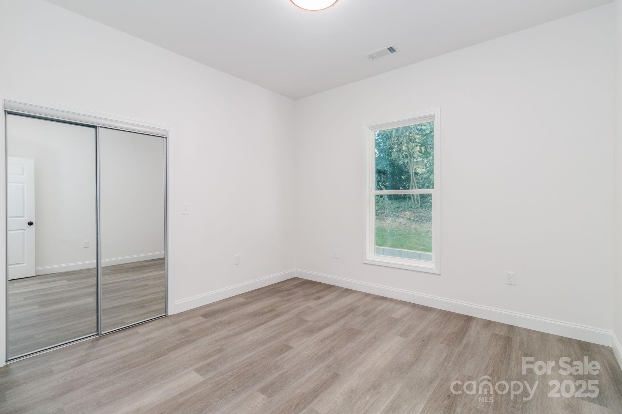 307 East Arch Street Lancaster, SC 29720 - Photo 35 of 43 an empty room with wooden floor closet and windows