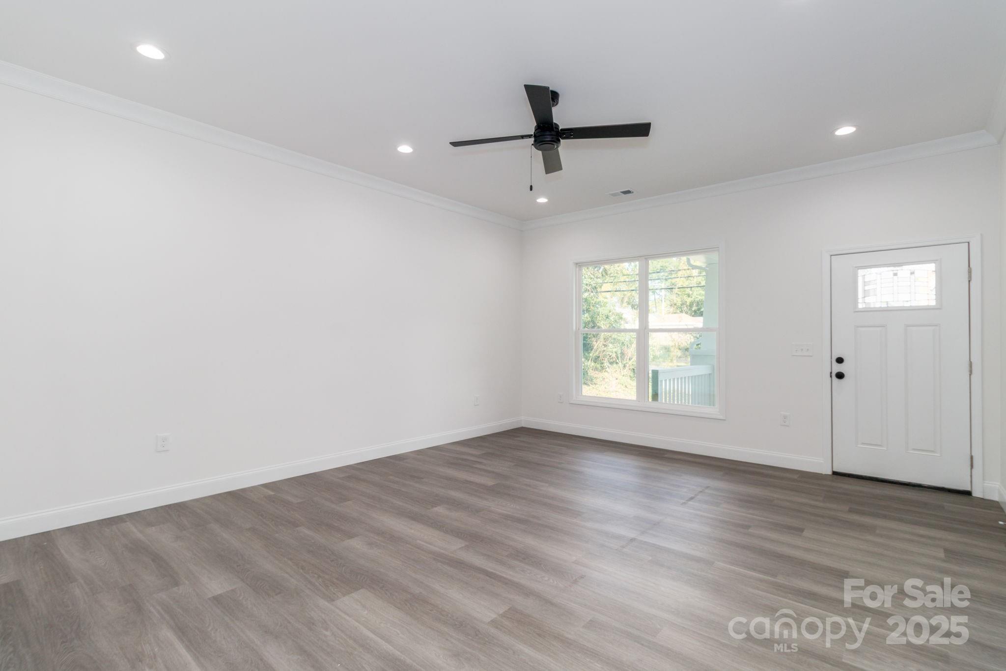 307 East Arch Street Lancaster, SC 29720 - Photo 8 of 43 an empty room with wooden floor fan and windows