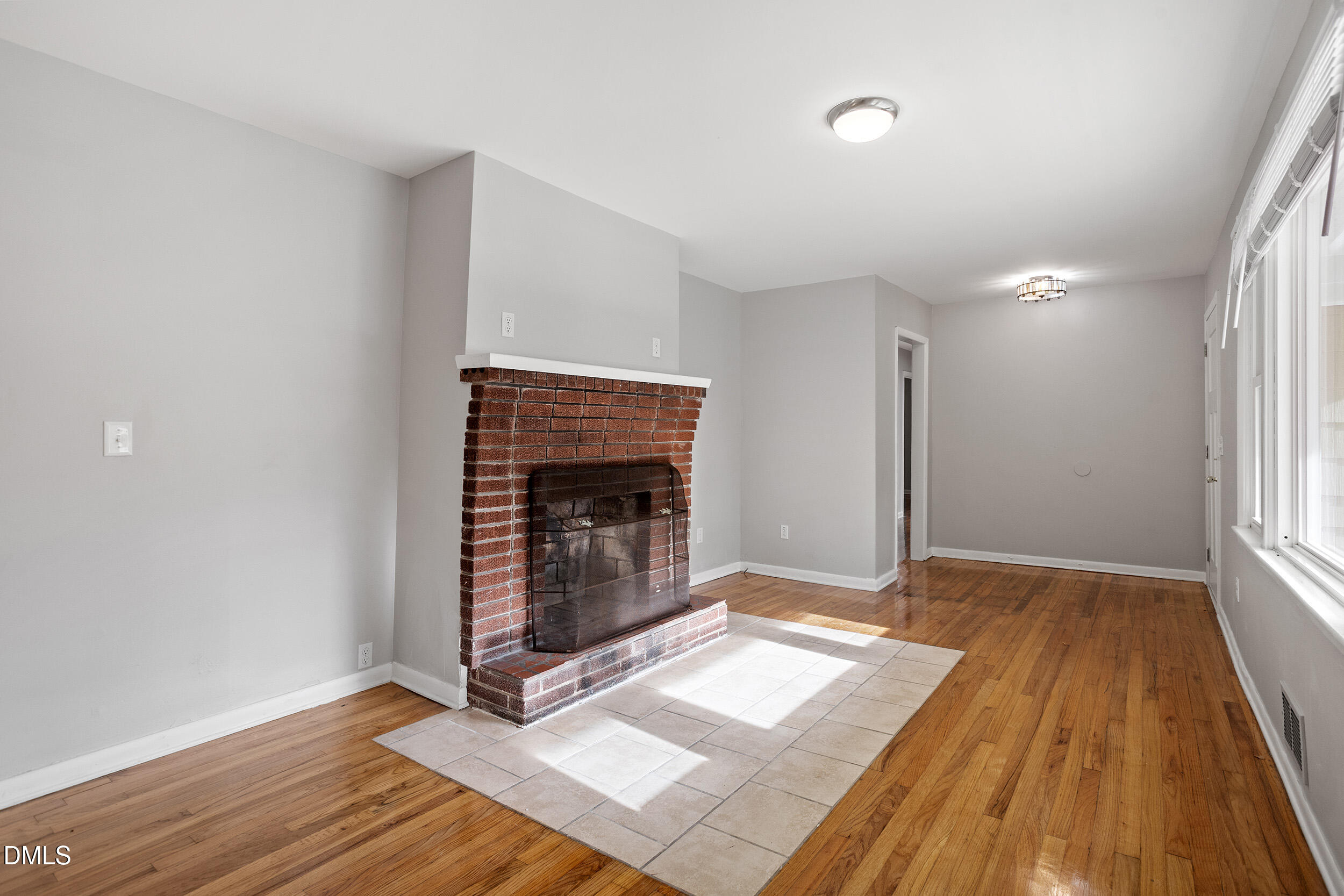 2414 Chapin Street Durham, NC 27707 - Photo 2 of 30 a view of an empty room with wooden floor and a fireplace
