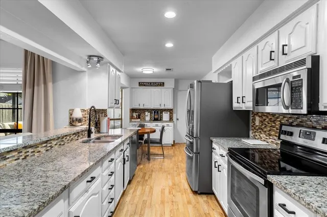 a kitchen with stainless steel appliances granite countertop a stove and a refrigerator