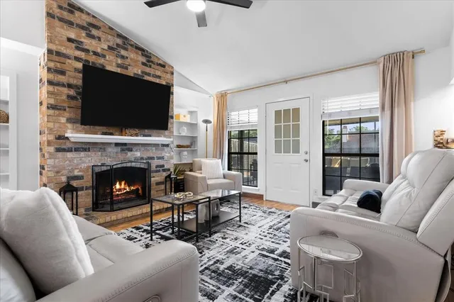 a living room with furniture a flat screen tv and a fireplace