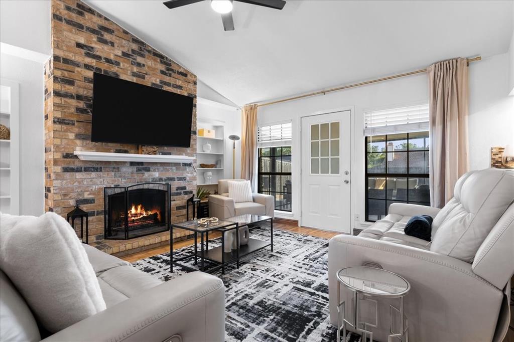 1208 Kesser Drive Plano, TX 75025 - Photo 15 of 33 Living area with lofted ceiling, a fireplace, wood finished floors, and built in features