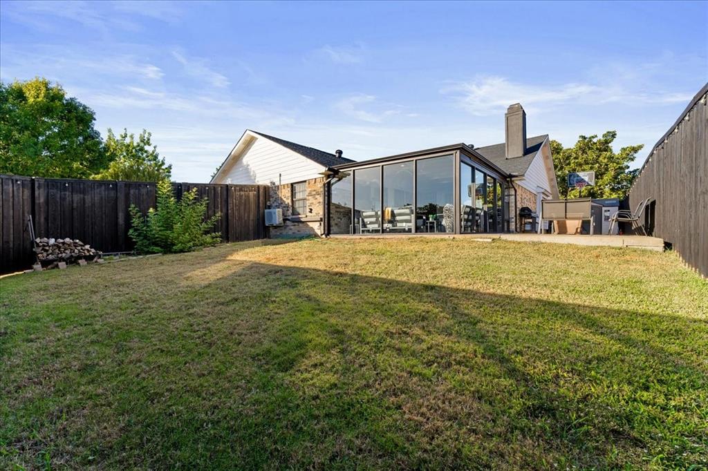 1208 Kesser Drive Plano, TX 75025 - Photo 2 of 33 Rear view of property featuring a fenced backyard, a chimney, a sunroom, and a patio area