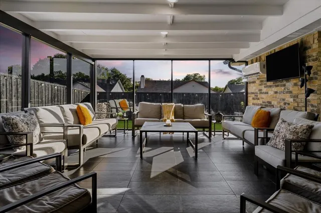 a living room with patio furniture and a flat screen tv
