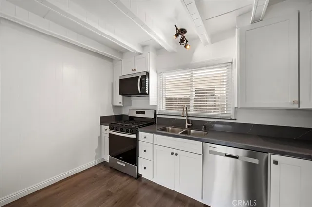a kitchen with granite countertop a sink and a stove top oven