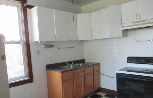 4132 West Cermak Road Chicago, IL 60623 - Photo 11 of 13 a kitchen with granite countertop white cabinets and a stove