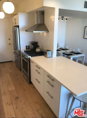 a kitchen with stainless steel appliances a sink stove and refrigerator