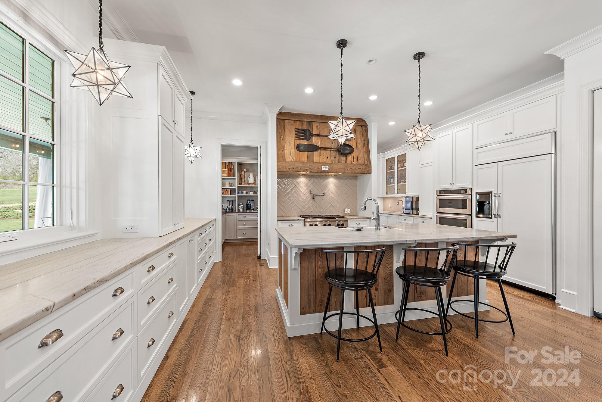 165 Timberside Drive Davidson, NC 28036 - Photo 7 of 48 a kitchen with stainless steel appliances granite countertop a kitchen island a stove a table and chairs in it