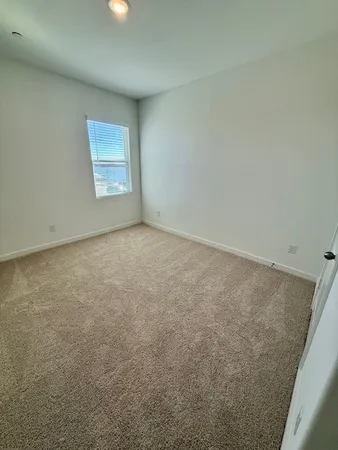an empty room with windows and ceiling fan view