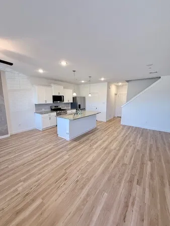 a view of kitchen with wooden floor and electronic appliances