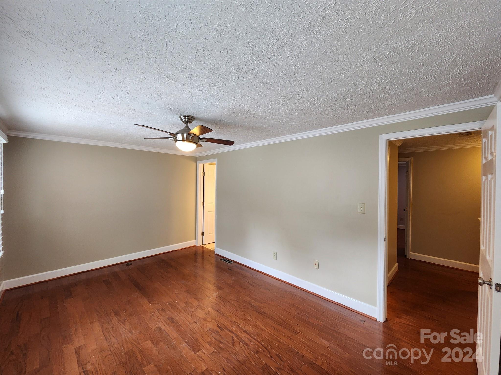 1201 Scaleybark Road, Unit D Charlotte, NC 28209 - Photo 19 of 37 an empty room with wooden floor chandelier fan and closet area