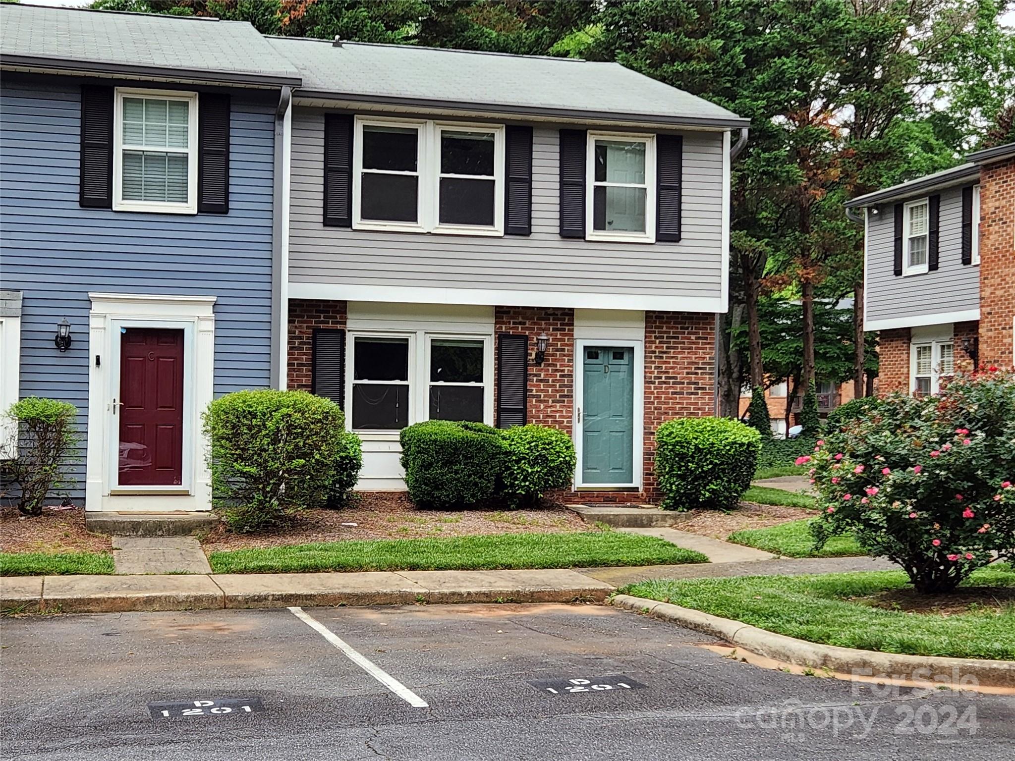 1201 Scaleybark Road, Unit D Charlotte, NC 28209 - Photo 2 of 37 a view of a brick house with a yard plants and large tree
