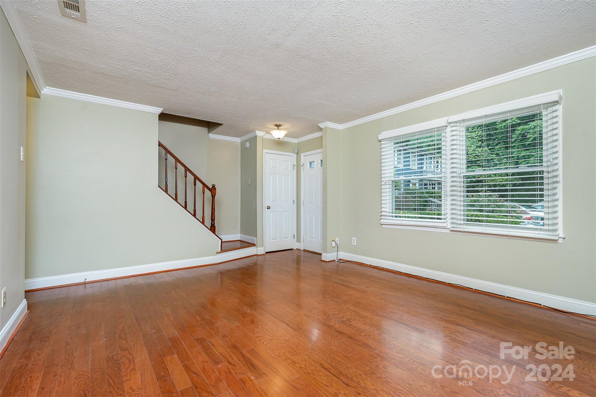 1201 Scaleybark Road, Unit D Charlotte, NC 28209 - Photo 6 of 37 a view of an empty room with wooden floor and a window