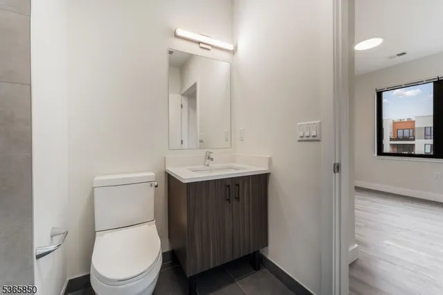 a bathroom with a toilet a sink and mirror
