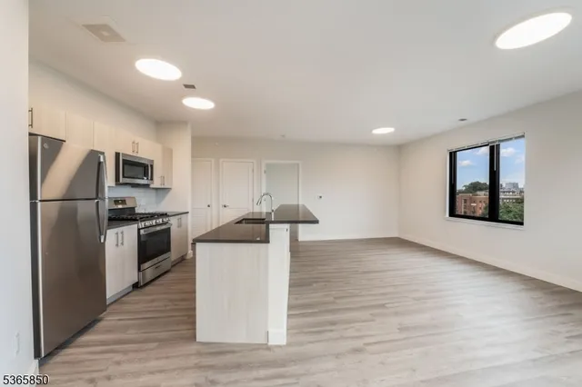 a kitchen with stainless steel appliances a refrigerator and a stove top oven