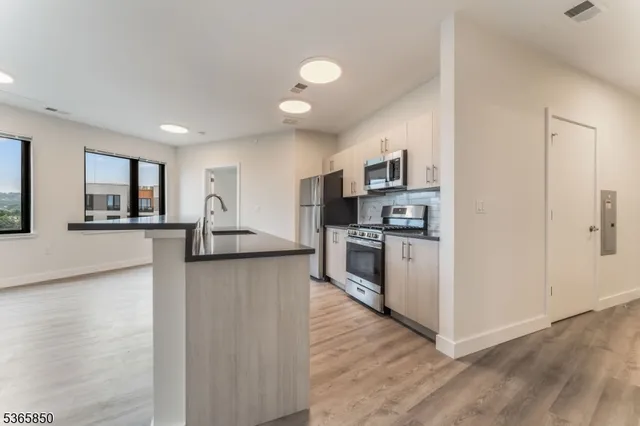 a kitchen with stainless steel appliances granite countertop a refrigerator sink and stove