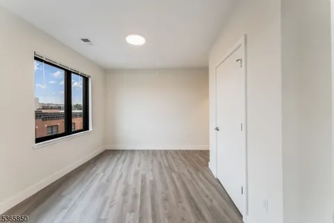 a view of a room with wooden floor and window