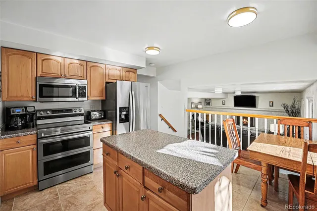 a kitchen with stainless steel appliances granite countertop a stove top oven a refrigerator and a microwave