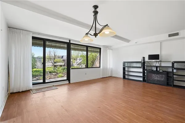 a view of empty room with wooden floor and floor to ceiling window