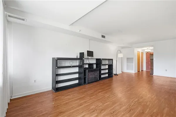 a view of empty room with wooden floor